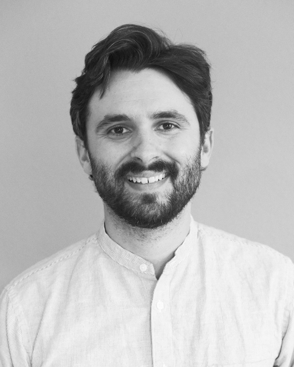 Mike Edmonds, smiling, in a striped band-collar shirt